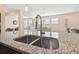 Modern double sink with a pull-down faucet in a granite countertop at 6230 Plover Meadow St, Lithia, FL 33547