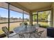 Screened patio with table and chairs, overlooking backyard at 6230 Plover Meadow St, Lithia, FL 33547