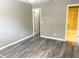 Bedroom with wood-look floors and access to bathroom at 7947 Radcliffe Cir, Port Richey, FL 34668