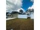 Tan house with gray garage door and a white fence at 8303 Begonia St, Spring Hill, FL 34608