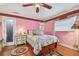 Charming bedroom with light pink walls, wood floors, and a ceiling fan at 9548 141St St, Seminole, FL 33776