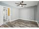 Simple bedroom with wood-look floors and access to another room at 1010 Emerald Creek Dr, Valrico, FL 33596