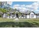 Two-story house with grey accents, lush lawn, and palm trees at 1010 Emerald Creek Dr, Valrico, FL 33596