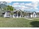 White and gray house with palm trees and a green lawn at 1010 Emerald Creek Dr, Valrico, FL 33596