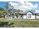 Two-story house with grey accents, lush lawn, and palm trees at 1010 Emerald Creek Dr, Valrico, FL 33596