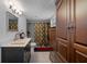 Bright bathroom featuring modern fixtures, a dark wood cabinet, a tiled shower and a large mirror at 1215 E Holland Ave, Tampa, FL 33612