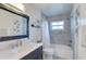 Updated bathroom with a bathtub, gray tile, and dark vanity at 12391 70Th St, Largo, FL 33773