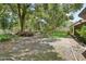 Landscaped backyard with mature trees and a brick patio at 12433 Shadow Ridge Blvd, Hudson, FL 34669