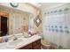 Bathroom with a floral shower curtain and updated vanity at 12433 Shadow Ridge Blvd, Hudson, FL 34669