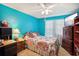 Bedroom with floral bedding, a large TV, and ample closet space at 12433 Shadow Ridge Blvd, Hudson, FL 34669