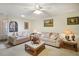 Living room with beige sofas, a coffee table and a view of the kitchen at 12433 Shadow Ridge Blvd, Hudson, FL 34669