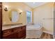 Primary bathroom featuring a corner soaking tub and granite vanity at 15927 Ternglade Dr, Lithia, FL 33547