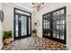 Spacious entryway with black French doors, wood floors, and a chandelier at 15927 Ternglade Dr, Lithia, FL 33547