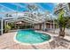 Inviting pool area with covered patio, brick pavers, and lush landscaping at 15927 Ternglade Dr, Lithia, FL 33547