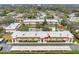 Aerial view of condo community showing building, pool, and surrounding landscape at 1750 Belleair Forest Dr # A15, Belleair, FL 33756