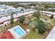 Aerial view of condo complex highlighting pool, pond, and lush landscaping at 1750 Belleair Forest Dr # A15, Belleair, FL 33756