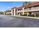 Condo building exterior showcasing Spanish-style architecture and landscaping at 1750 Belleair Forest Dr # A15, Belleair, FL 33756