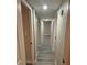 Hallway with grey wood-look flooring, doors on either side, and neutral walls at 1804 Cadillac Cir, Tampa, FL 33619