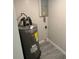 Small utility room featuring gray water heater and breaker box on light neutral walls with gray floors at 1804 Cadillac Cir, Tampa, FL 33619