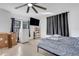 Bright bedroom featuring ceiling fan, mounted TV, boxes, mini fridge, shelving, and neutral decor at 2070 28Th St, Sarasota, FL 34234