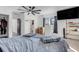 Bright bedroom featuring ceiling fan, mounted TV, boxes, mini fridge, shelving, and neutral decor at 2070 28Th St, Sarasota, FL 34234