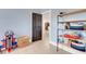 Hallway with black door and shelving unit, leading into the home at 2070 28Th St, Sarasota, FL 34234