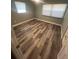 Bedroom featuring updated wood-look floors, two windows and neutral paint at 22065 Malone Ave, Port Charlotte, FL 33952