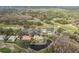 Aerial view showcasing a home with a pool near a golf course, clubhouse, and surrounding greenery at 2987 Wentworth Way, Tarpon Springs, FL 34688