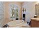 Bathroom with large window over the tub, sconce lighting, and neutral tile surround at 2987 Wentworth Way, Tarpon Springs, FL 34688