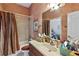 Bathroom featuring a shower-tub combo and vanity with framed mirror and earth-toned color scheme at 2987 Wentworth Way, Tarpon Springs, FL 34688