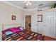 Bedroom with ceiling fan, tray ceiling, and a doorway leading to another room at 2987 Wentworth Way, Tarpon Springs, FL 34688