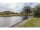 Scenic view of a tranquil pond near a luxurious home and sprawling golf course at 2987 Wentworth Way, Tarpon Springs, FL 34688