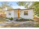 Quaint house with yellow door, white exterior, and landscaping at 3034 Burlington N Ave, St Petersburg, FL 33713