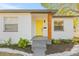 Front view of a renovated home with a yellow door and modern updates at 3034 Burlington N Ave, St Petersburg, FL 33713