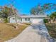 Ranch-style home with a white garage door and a spacious driveway at 310 Shirley Dr, Largo, FL 33770