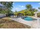 Lush backyard with a sparkling pool, lounge chairs, and outdoor seating perfect for relaxation and entertaining at 3310 Carib Rd, Tampa, FL 33618