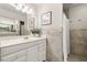 Bright bathroom with a sink vanity, large mirror, and neutral-tone tile at 3310 Carib Rd, Tampa, FL 33618