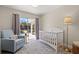 Adorable Bedroom with a crib, blue armchair, and view of the backyard pool at 3310 Carib Rd, Tampa, FL 33618