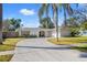 Charming single-story home with a curved driveway, attached garage, and lush tropical landscaping at 3310 Carib Rd, Tampa, FL 33618