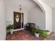 Charming front porch with dark-stained door, beautiful plants, bench, and textured walls, creating a welcoming entrance at 3310 Carib Rd, Tampa, FL 33618