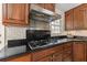 Kitchen cooktop and vent hood with custom cabinets, granite countertops, and mosaic backsplash at 3310 Carib Rd, Tampa, FL 33618