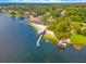 Beautiful aerial shot of a lake, pier, sandy beach, and surrounding homes amid lush trees at 3310 Carib Rd, Tampa, FL 33618