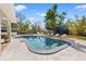 Sparkling pool area with lounge chairs, umbrellas, and lush landscaping providing a serene outdoor retreat at 3310 Carib Rd, Tampa, FL 33618