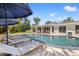 A great view of the pool, lounge chairs, and an outdoor living area with couches, tables, and a wet bar at 3310 Carib Rd, Tampa, FL 33618