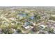 An aerial view of a residential area featuring a pond, green trees, and other houses surrounding the area at 3499 43Rd N St, St Petersburg, FL 33713