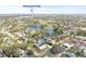 An aerial view of a residential area featuring a pond, green trees, other houses, and Downtown St Pete in the distance at 3499 43Rd N St, St Petersburg, FL 33713