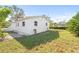 This backyard features white siding, a lush lawn, trees, and gravel accents around the perimeter of the home at 3499 43Rd N St, St Petersburg, FL 33713