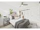 Bright bedroom featuring wood floors, a ceiling fan, and a modern sliding barn door at 3499 43Rd N St, St Petersburg, FL 33713