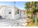 The exterior of this house features white siding, a gravel walkway, and lush tropical landscaping at 3499 43Rd N St, St Petersburg, FL 33713