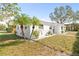 Inviting exterior of a home with tropical landscaping, featuring palm trees and well-maintained lawn at 3499 43Rd N St, St Petersburg, FL 33713